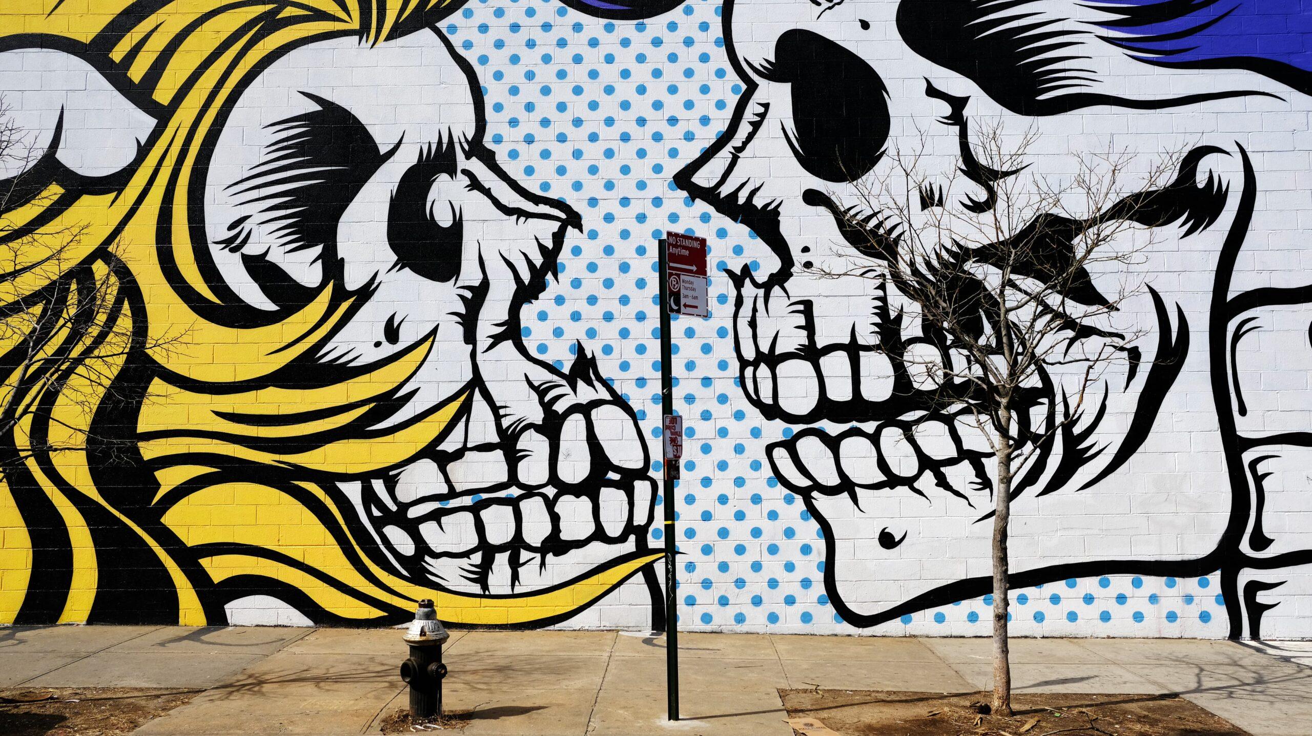 Fresque murale de l'artiste britannique D*Face représentant, dans un style pop, une femme et un homme se regardant. Leurs visages sont remplacés par des crânes.