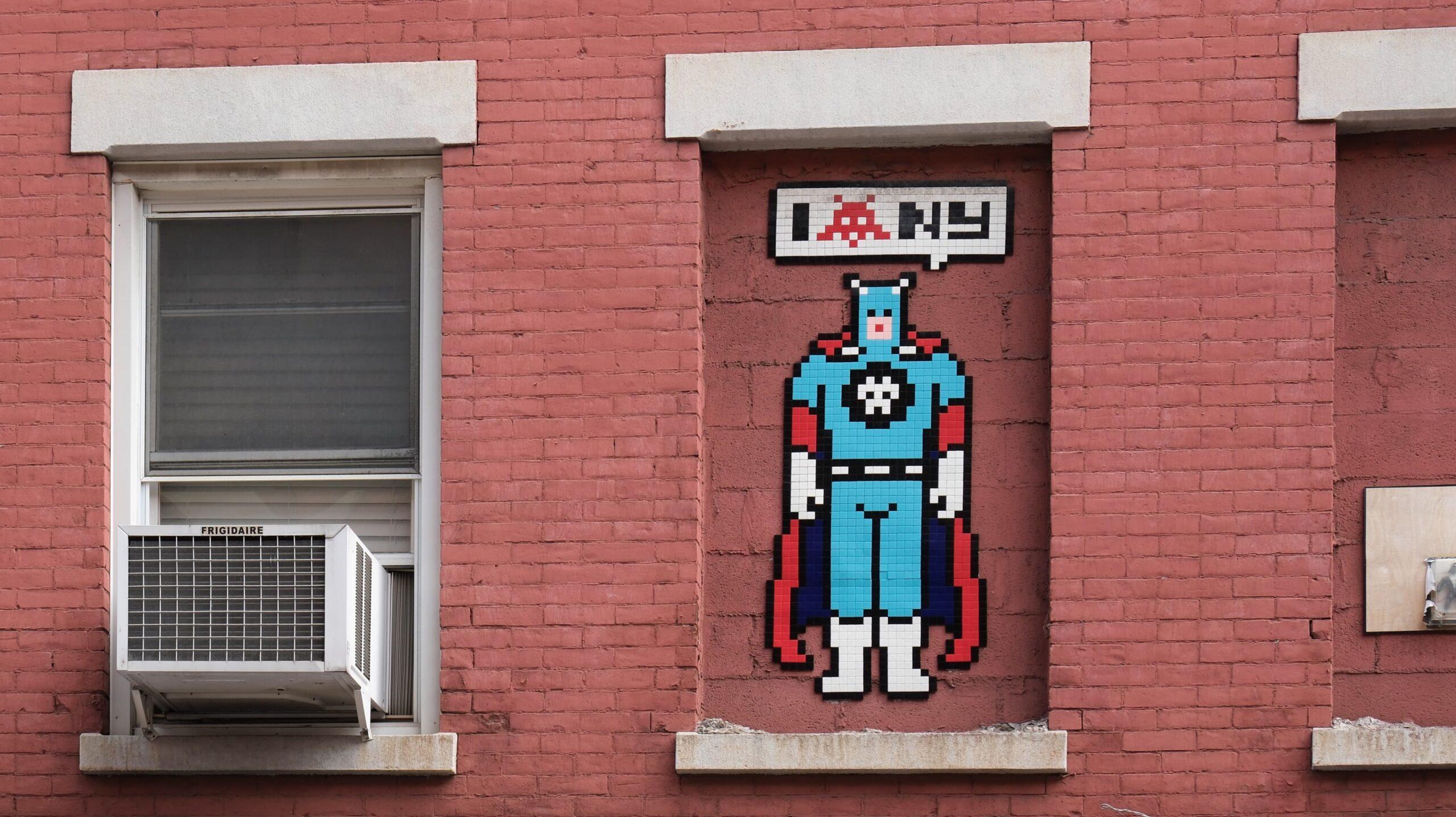 Oeuvre de pixel art réalisée en mosaiques sur un mur en briques de Little Italy par l'artiste Invader. Elle représente Captain America disant I love NY, le coeur étant remplacé par un space invader.